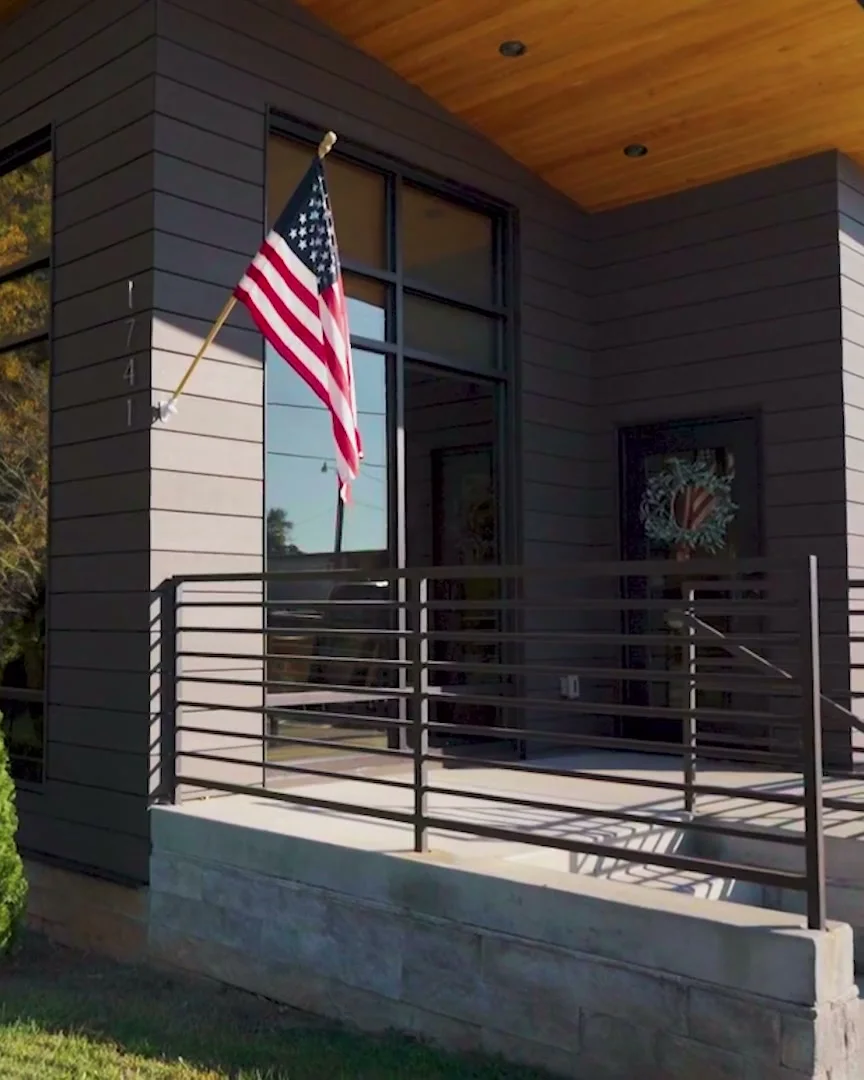 The front entrance of Winchester Family Dentistry: an American flag by the tall windows and the railing up to the door.
