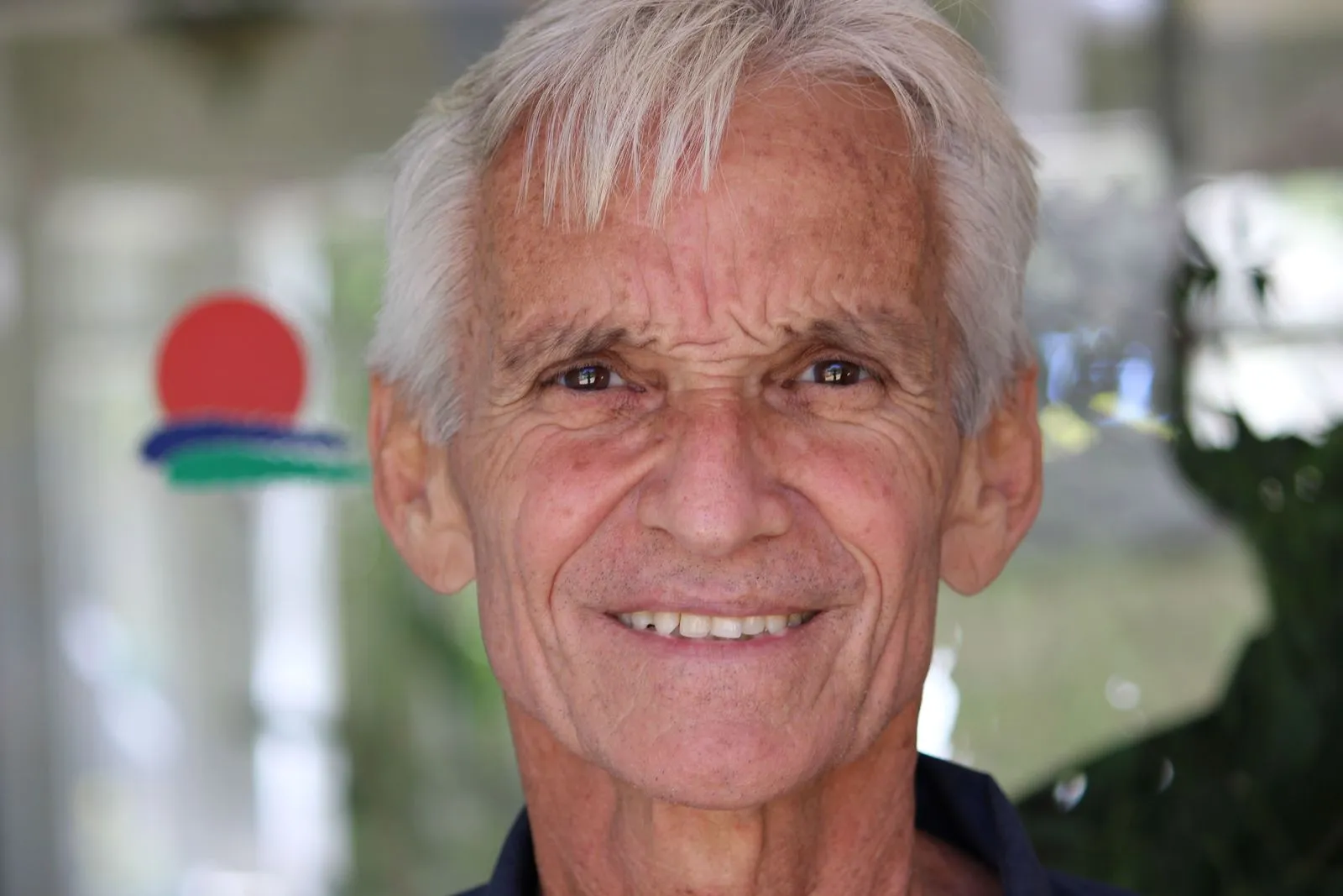 A silver-haired man smiling warmly at the camera.